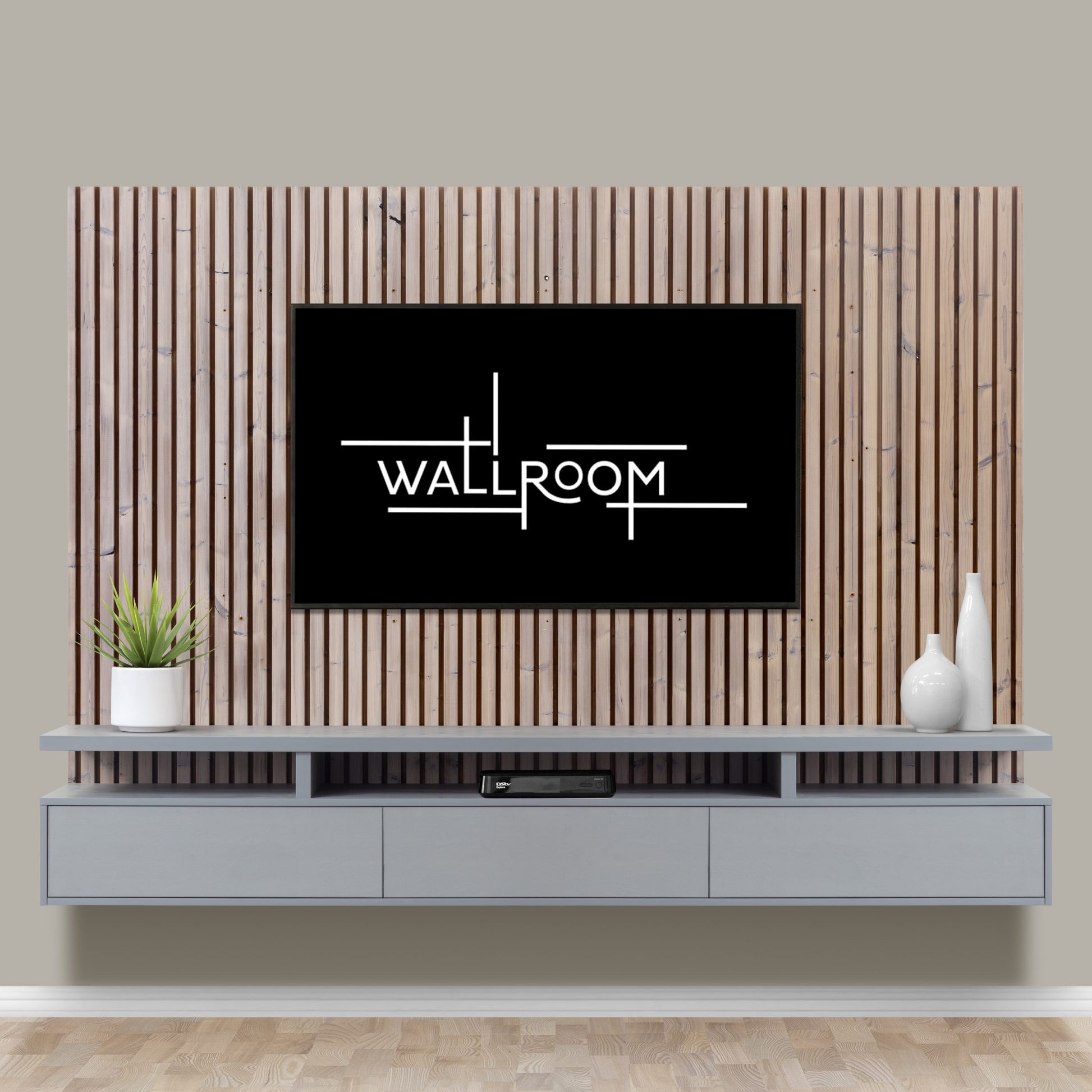 A living room wall featuring a modern floating wall-mounted TV unit on a slatted wood panel and includes a floating shelf for media storage.