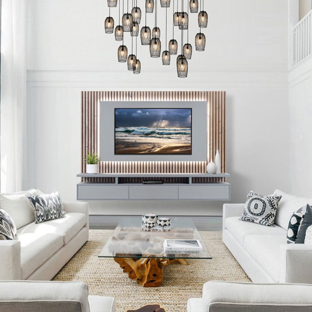 A well-lit living room with elegant white sofas, a wooden center table, displaying a wall-mounted tv stand, surrounded by hanging light fixtures.