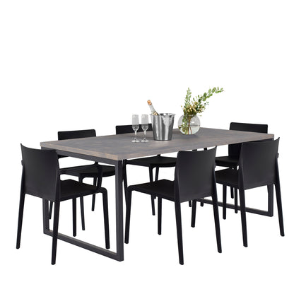 A modern dining table and chairs with a sleek, dark wooden table and six black chairs, elegantly set with wine glasses, a bottle in a silver bucket, and a vase with greenery (side view)