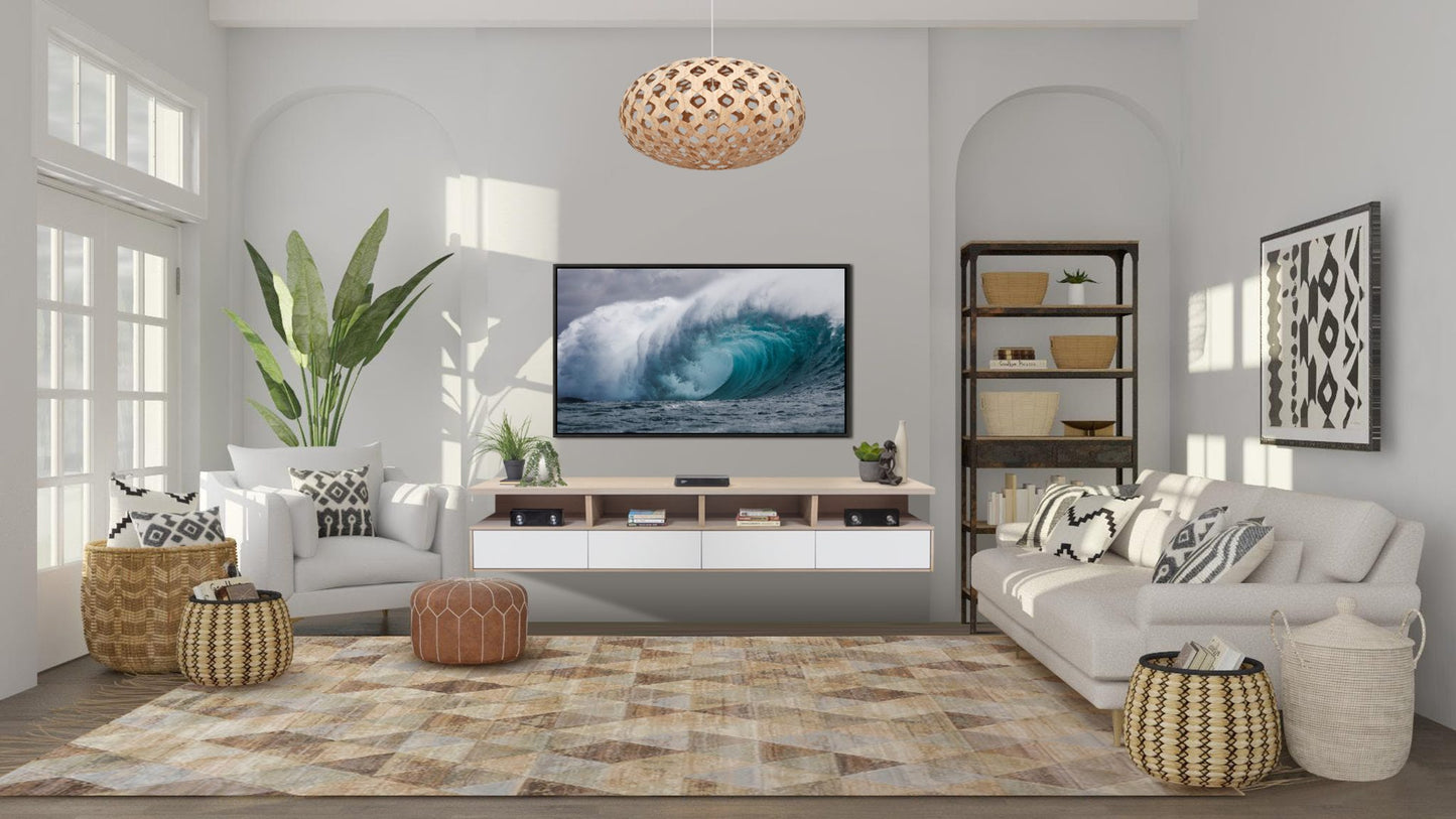 A modern living room with a coastal theme, featuring a large tv on a floating tv shelf, a plush sofa, woven baskets offering ample storage, an array of decorative pillows, and green indoor plants,