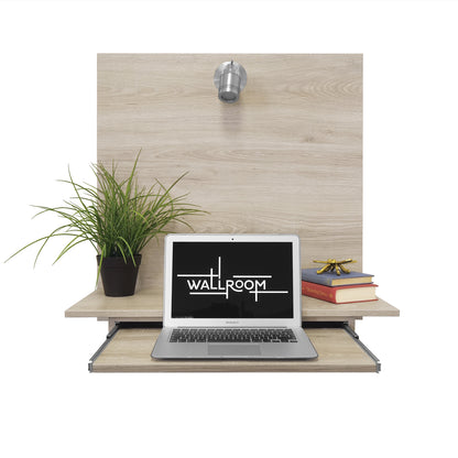 A modern minimalist fold-away floating wall-mounted desk setup with an open laptop, a green potted plant, and a neat stack of red and yellow books to the side